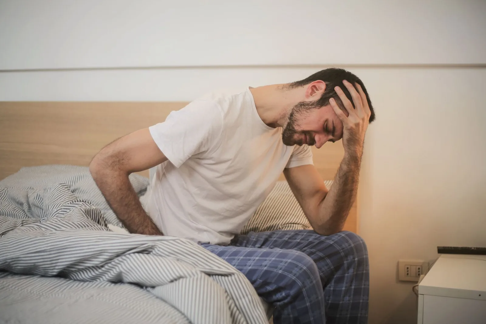 Adult resting in a dim room while managing a migraine attack