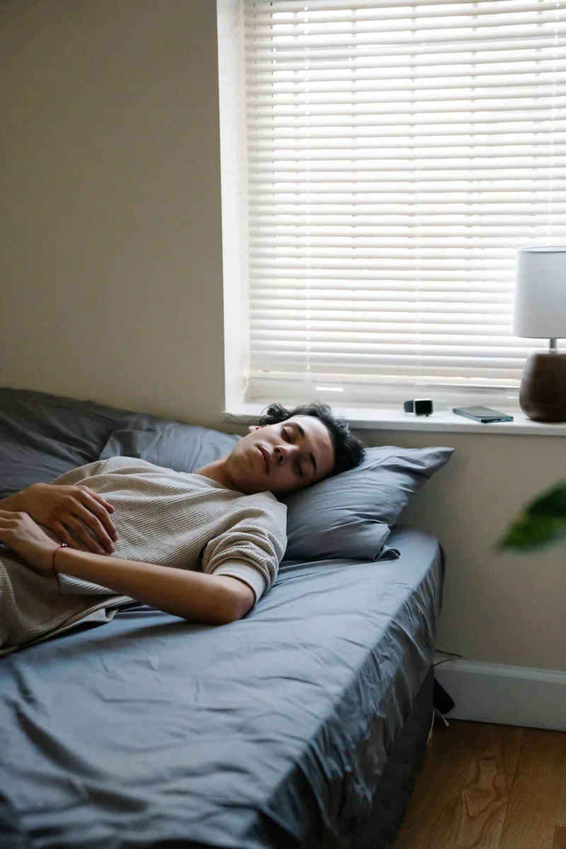 Person resting in a calm bedroom with soft morning light