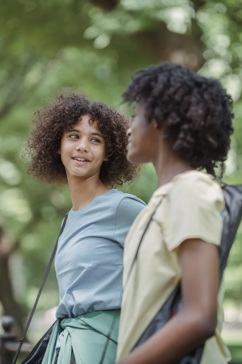 Two friends sharing a quiet, supportive conversation outdoors