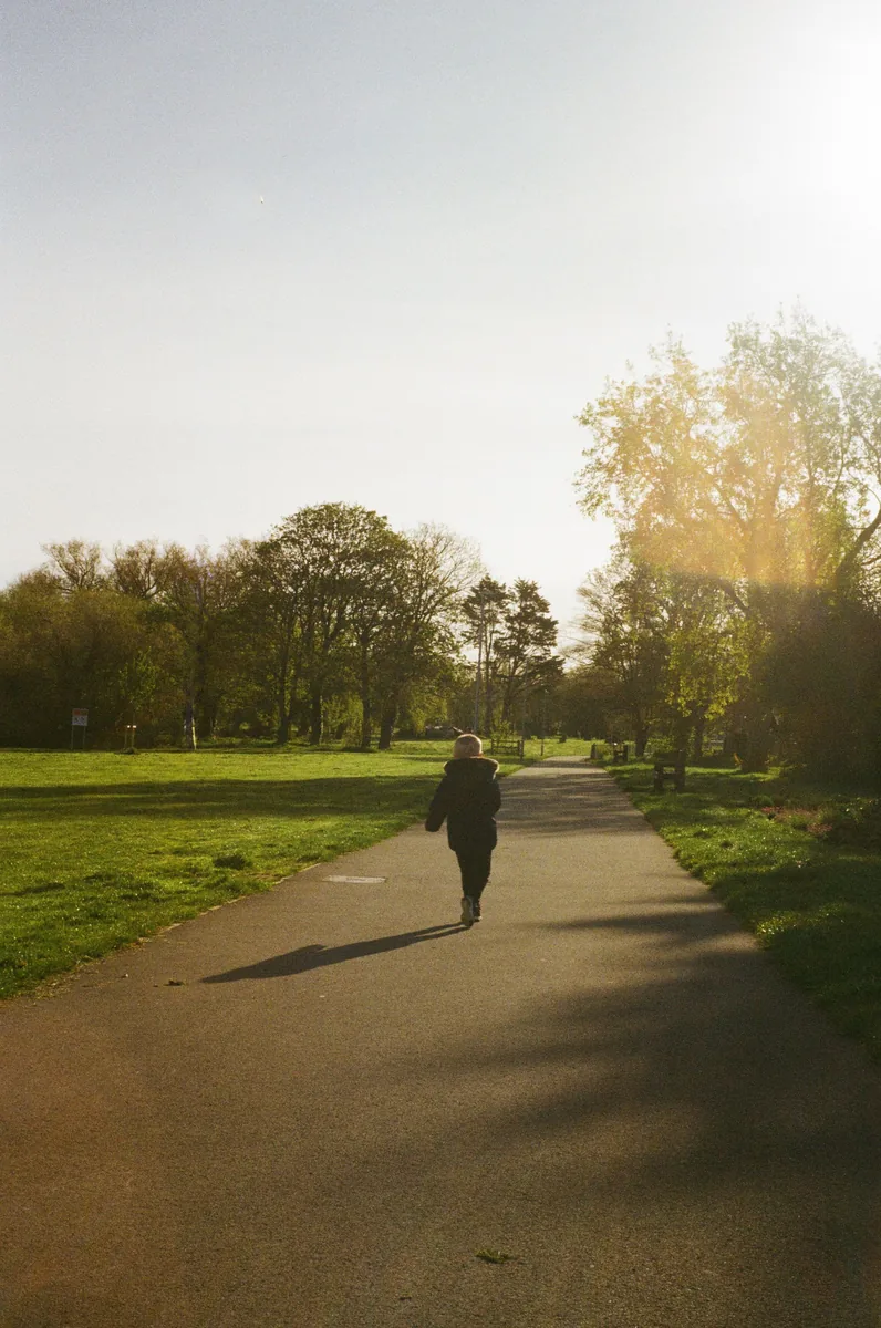 Person taking a restorative walk through a green park